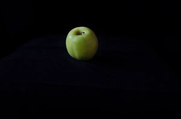 Ein grüner Apfel auf schwarzem Hintergrund — Stockfoto