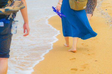 Kumsalda yürüyen kadınların ayakları