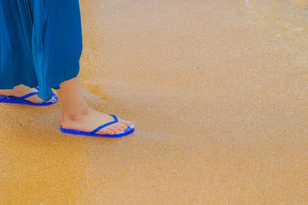 Feet of women who walk the sandy beach