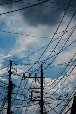 Güç hatlarının silueti bulutların arasında uzanıyor.