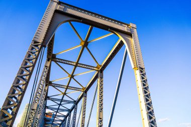 Mavi gökyüzüne uzanan demir bir köprü