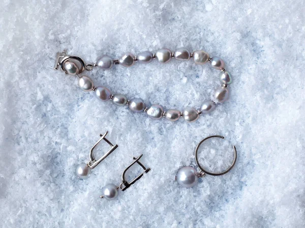 ホワイト雪の背景に豪華なエレガントな黒のバロック様式の真珠のイヤリング リングとブレスレット クローズアップショット — ストック写真