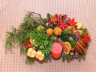 Çam dalları, portakal dilimleri, pamuk, mum ve yapraklardan oluşan Noel kompozisyonu. Yakın çekim. Hafif arkaplanda