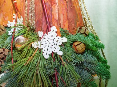 Köknar ağacı dalları, ağaç kabuğu, selvi kozalakları, Noel oyuncakları ve topların Noel kompozisyonu. Açık bej arkaplanda