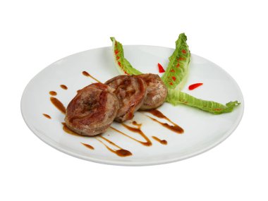 Beyaz yuvarlak seramik tabakta kızarmış domuz madalyonu. Beyaz arkaplanda izole