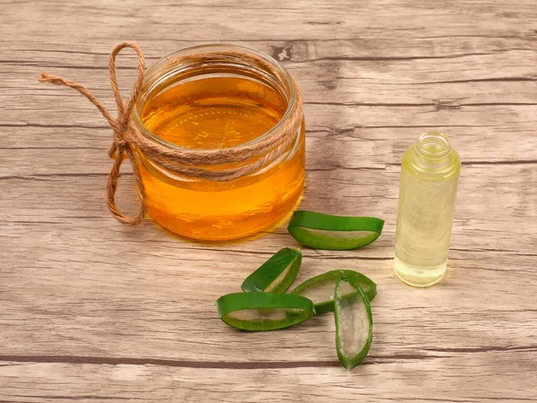 Aloe Vera ve bal, açık ahşap arka planda yakın plan. Dilimlenmiş Aloe vera doğal organik yenileme kozmetikleri, alternatif tıp, organik cilt bakımı konsepti