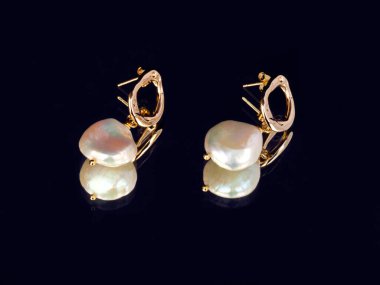 Lükslü, zarif, mavi ayna arka planında inci küpeler. Yansımayla. Yakın plan çekim. Seçici odak