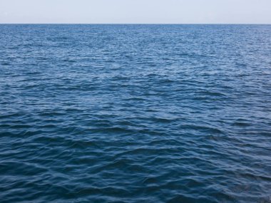 Deniz yüzeyinde parlak mavi dalgalar