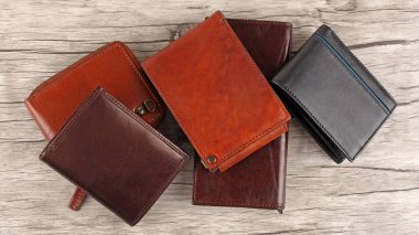 Açık ahşap arka planda yeni deri renkli cüzdanlar. Üst görünüm