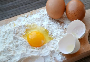 yumurta, tereyağı ve tahta kaşık yemek kartı üzerindeki beyaz un