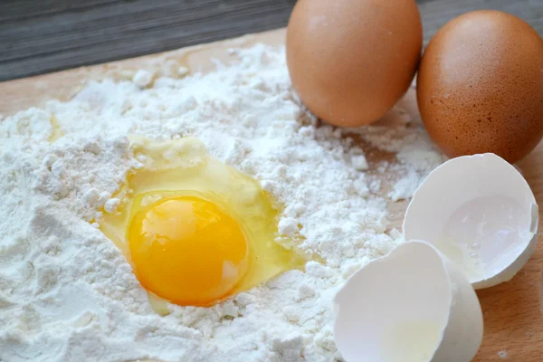 Fehér liszt, tojás, vaj és fakanállal a főzés fórumon — Stock Fotó