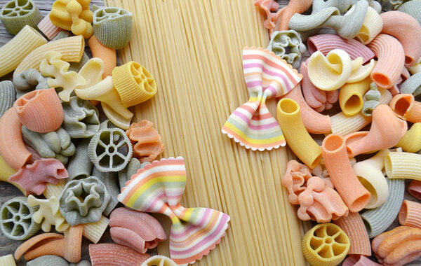 Set of different kinds of colorful Italian pasta on wooden table