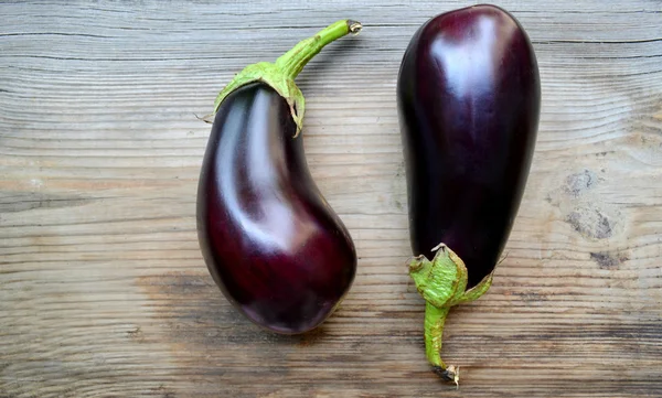 Frisk och läcker lila äggplantor på trä bakgrund — Stockfoto