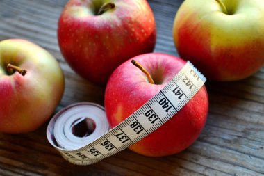 diyet kavramı ile elma kırmızı ve sarı ve Beyaz ahşap masa kasette ölçme