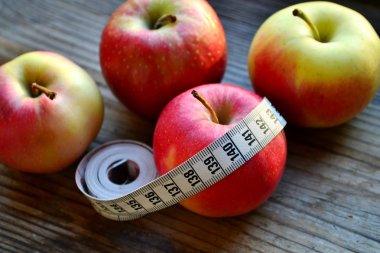 diyet kavramı ile elma kırmızı ve sarı ve Beyaz ahşap masa kasette ölçme