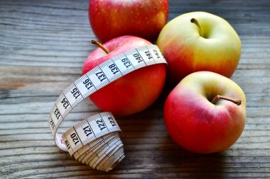 diyet kavramı ile elma kırmızı ve sarı ve Beyaz ahşap masa kasette ölçme