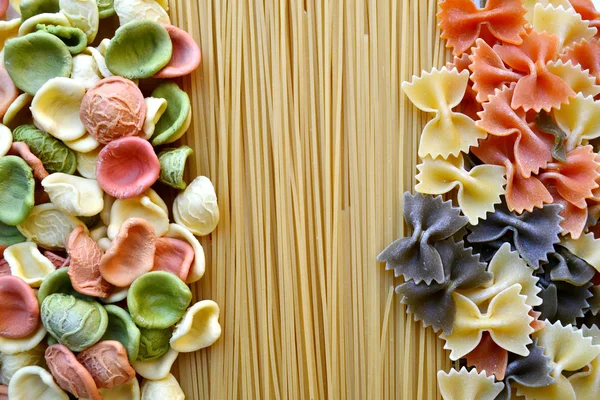 Ensemble de différents types de pâtes italiennes colorées sur table en bois — Photo