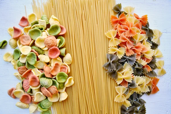 Conjunto de diferentes tipos de massas italianas coloridas na mesa de madeira — Fotografia de Stock