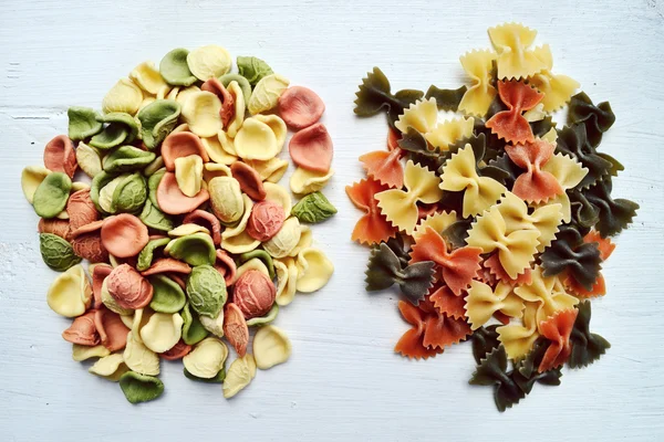 Conjunto de diferentes tipos de massas italianas coloridas na mesa de madeira — Fotografia de Stock