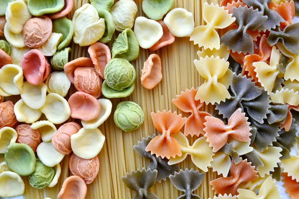 Set di diversi tipi di pasta italiana colorata su tavola di legno — Foto Stock