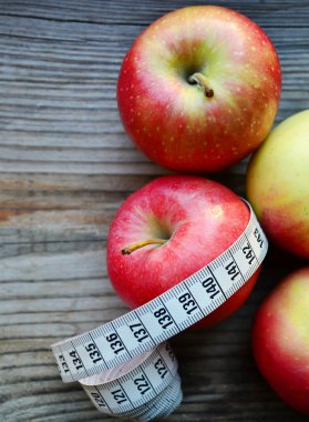 diyet kavramı ile elma kırmızı ve sarı ve Beyaz ahşap masa kasette ölçme