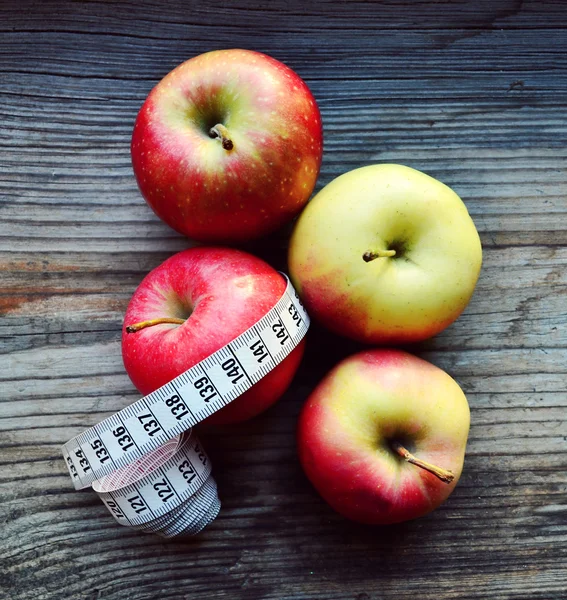 Pojęcie diety z jabłka czerwone i żółte i białe Miara zwijana na drewnianym stole — Zdjęcie stockowe