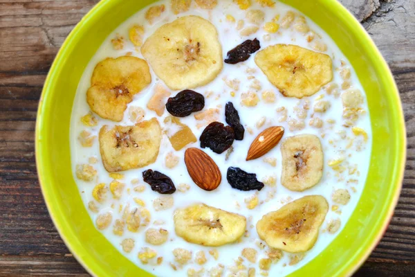 Bol vert rempli de granola avec lait, noix et fruits secs — Photo