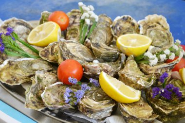 Taze ve çiğ istiridye limon ve kiraz domates ile