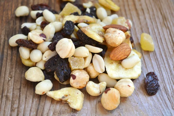 Смесь различных орехов и консервированных фруктов на деревянном столе — стоковое фото