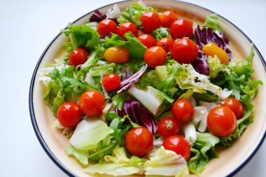 Lezzetli vejetaryen kırmızı ve sarı kiraz domates, roka, lahana ve marul salatası