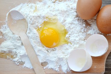 yumurta, tereyağı ve tahta kaşık yemek kartı üzerindeki beyaz un