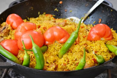 tencereye domates ve yeşil biber biber Özbek pilavı ile