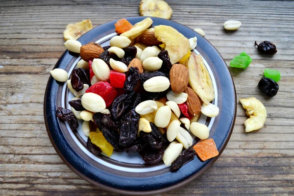 Mezcla de diferentes frutos secos y frutas confitadas sobre mesa de madera — Foto de Stock