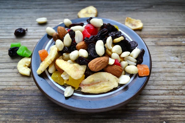 Mix van verschillende noten en gekonfijte vruchten op houten tafel — Stockfoto