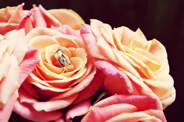Engagement ring on a beautiful wedding bouquet of pink roses — Stock Photo, Image