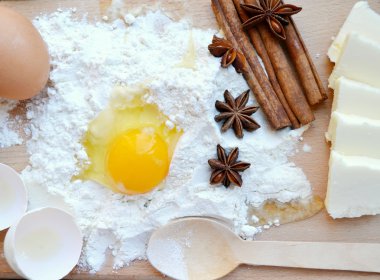 beyaz un yumurta, tereyağı, tarçın ile sopa, baharatlı anason yıldız ve tahta kaşık yemek oyun tahtası