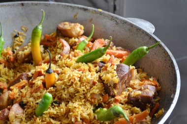 tencereye domates ve yeşil biber biber Özbek pilavı ile