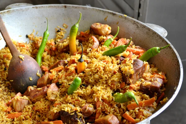 Olla grande con pilaf uzbeko con tomates y chiles verdes —  Fotos de Stock