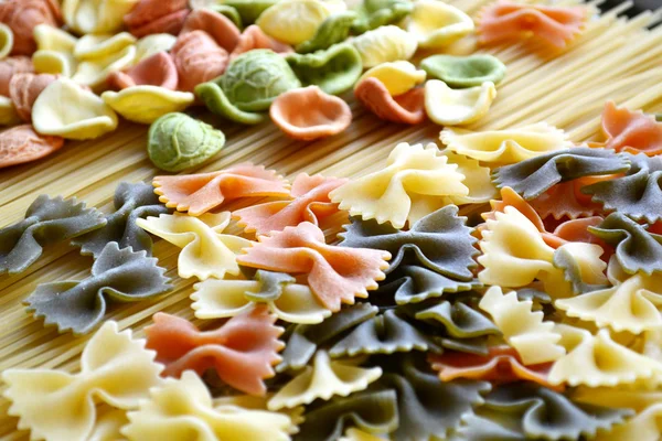 Set di diversi tipi di pasta italiana colorata su tavola di legno — Foto Stock