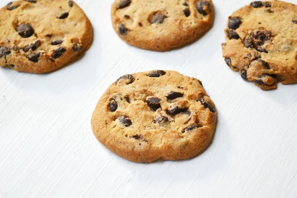 Ízletes csokoládé cookie-kat a fehér fa asztal — Stock Fotó