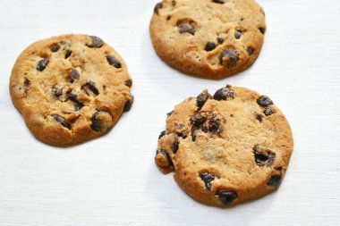 Beyaz ahşap masa üzerinde lezzetli çikolata kurabiye