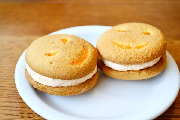 Two smiling biscuits on white plate — Stock Photo, Image