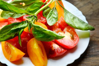 Bir tabak taze Fesleğenli domates sarı ve kırmızı