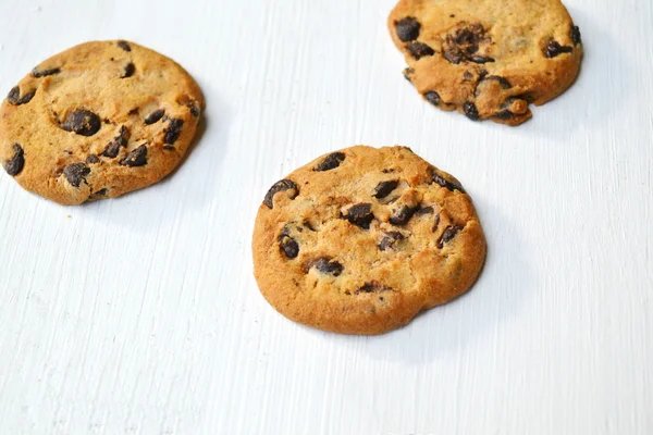 Ízletes csokoládé cookie-kat a fehér fa asztal — Stock Fotó