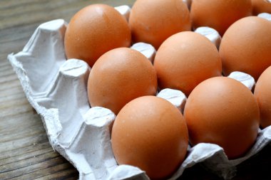 Ahşap masa üzerinde bir sepet içinde kahverengi yumurta