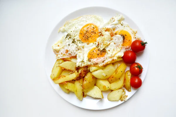 Grande assiette ronde pleine d "œufs frits, de frites et de tomates cerises - un petit déjeuner continental traditionnel — Photo