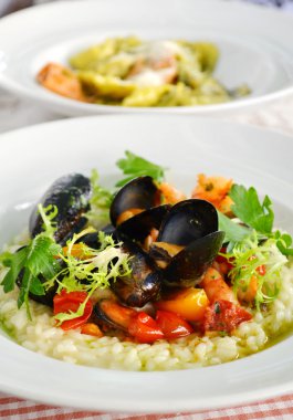 Deniz ürünleri midye ve karides beyaz tabakta bir restoranda lezzetli risotto