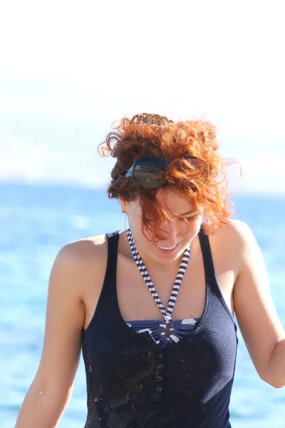 Glücklich lächelnde rothaarige Frau im Bikini, die Spaß am Strand am Meer hat — Stockfoto