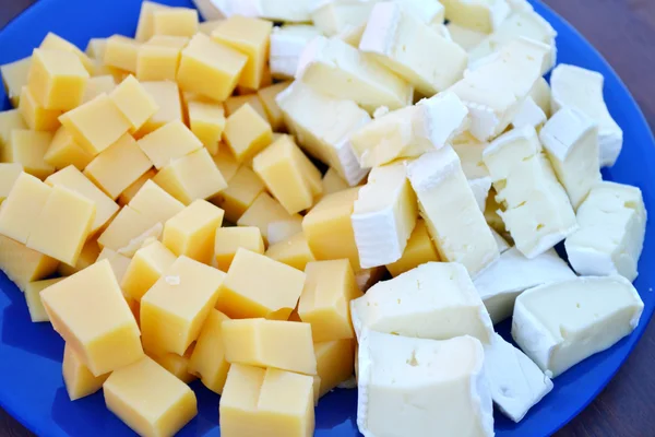 Placa azul con diferentes tipos de queso — Foto de Stock