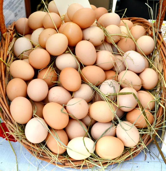Органічні коричневі яйця в кошику на вуличному ринку — стокове фото